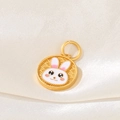 Detail of a golden round pendant with a white cartoon rabbit design and wave relief textures - D1457 (Rabbit - Enamel)