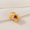 Macro shot of gold-plated astronaut charm with purple enamel star on white silk - Astronaut Purple Star Style (D1468)