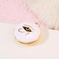 Colgante relicario dorado con Ojo de Horus y gema roja sobre arena rosa - Estilo Ojo De Horus Blanco (H-7740)