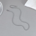 Minimalistische zilveren roestvrijstalen gedraaide schakelketting op een grijze ondergrond - Zilver