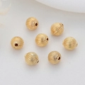 Macro shot of 14k gold-filled hollow striped beads for DIY jewelry making and craft projects - 14K Gold Spiral Striped Round Bead (H-5947)
