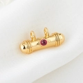 Detail view of golden cylindrical pendant with red cabochon stone and polished finish - Cylindrical With Red Rhinestone (H-6666 Red)