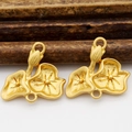 Close-up of matte gold lotus flower charms for jewelry making with natural wood background - Lotus Style (D263)