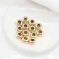 Close-up of 14K gold plated stopper beads for DIY jewelry making on white ceramic - 5.5mm / 14K Gold