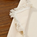 Beigefarbene Tischmatte aus Baumwollleinen mit Fransen auf dunklem Holztisch - 30*30cm / Beige