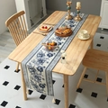 Chinesischer Tischläufer mit blauen Rosen und weißen Quasten auf einem Holztisch - 35*150 / Blau