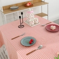 Pink and white checkered linen tablecloth with delicate white lace trim in a cozy setting - Pink