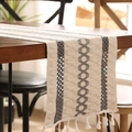 Boho Tischläufer in Beige und Grau mit Quasten auf einem dunklen Holztisch platziert - 30*220 / Grau Drei Seile