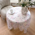 Detalle de mantel redondo de malla con bordado floral rosa y elegante borde de encaje - 130x260cm / Bordado de Flores Pentagonales