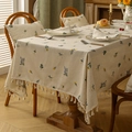 Close-up of linen tablecloth featuring floral embroidery and decorative tassel edges - Wheat Ear Embroidery / 135*135