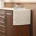 Beige table runner with gold leaf embroidery on dark wood cabinet in home setting - Gold Leaf Edging