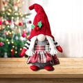 Gnome de Noël en peluche avec bonnet rouge et tresses sur fond d'arbre de Noël festif - Style Femme