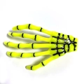Macro shot of fluorescent yellow skeleton hand hair clip with detailed black bone joints - Yellow