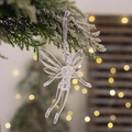 Durchsichtiger Engel-Anhänger aus Acryl am verschneiten Weihnachtsbaum mit warmem Licht - Transparente Fee
