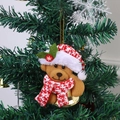 Gros plan d'un ours en peluche de Noël avec clochette suspendu sur un sapin de Noël - Ours