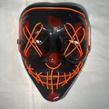 Halloween LED mask with orange glowing cross eyes and red blood splatter on black base - Orange