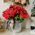 Künstliche rote Geranien im Vintage-Metallkübel mit rustikaler Schleife für Deko - Roter Blumenampel