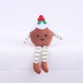 Macro detail of Christmas pudding plush doll with festive holly berries and striped legs - Brown