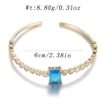Open bangle in gold with a rectangular blue gemstone and white zircon accents - Rectangular Blue Gem Pave Style (YJC-F-09)