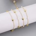 Detail of gold-plated chain with white pearls wrapped around a white cylinder - Pearl and Gold Bead Style (6) / 1m