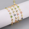 Detailed close-up of gold chain featuring multi-colored crystals and textured floral metal links - Colorful Gemstone Style (8) / 1m