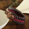 Macro shot of skull helmet charm on woven paracord survival bracelet with bronze finish - Spartan Skull Bronze Clasp Brown Red Rope (ABL163-3)