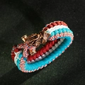 Detailed view of handmade paracord bracelet with antique bronze dragon head buckle - Cyan Red White (ABL164-3)