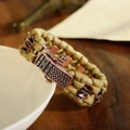 Close-up of khaki paracord survival bracelet with vintage bronze buckle on a white bowl - 19cm / Khaki (ABL165-3)