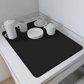 Detalle del tapete de secado negro con juego de té de cerámica blanca sobre mármol - Negro puro