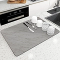 Detalle de una alfombrilla de secado para cocina con patrón de mármol gris y vajilla - Gris Nube Mármol