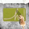 Detail of green woven door mat with white 'hi!' text and orange cat on grey floor - Green