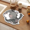 Close-up of cat-shaped absorbent mat on wooden counter with teapot and ceramic cups - Cat