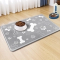 Detail of gray diatom mud pet feeding mat with white bone and paw patterns on wood floor - 30*40cm / Style 16