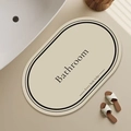 Detail view of oval beige diatomite bathroom mat with elegant black double border and text - 40*60cm (Skin-friendly Velvet) / Beige
