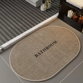 Dettaglio tappeto bagno ovale effetto lino con scritta B ATHROOM su pavimento moderno - Bagno-4 / Piccolo (Lino Farina Fossile)