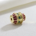 Macro detail of luxury geometric gold charm with red enamel and green marquise zircons - Red Green Stone Drum (03)