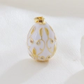 Macro shot of egg-shaped pendant with white enamel, gold vines, and crystal inlay - White (01)