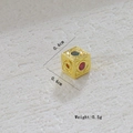 Vista macro detallada de un dije de cubo chapado en oro de 18k con piedras preciosas - Cubo de Grecas Diamante Rojo Verde (08)