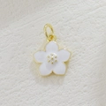 Macro shot of a cherry blossom pendant with white enamel petals and gold flower core - White Glazed Sakura Style (7)
