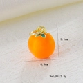 Detailed macro view of orange fruit pendant with green leaf and 18k gold plating details - Orange