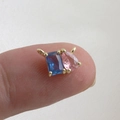 Macro view of mini water drop zircon pendant with blue and pink stones on a fingertip - Blue Rectangle & Pink Tear Drop