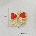 Macro view of a 18k gold plated butterfly pendant with red enamel and hammered texture - Hammered Red Bowknot Style