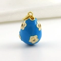 Detail of blue enamel Easter egg pendant with white floral patterns and small crystals - Blue Rhinestone Floral Style
