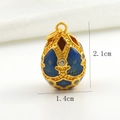 Detailed view of 18k gold plated Faberge egg pendant with blue enamel and white crystals - Dark Blue Hollow Rhinestone Style