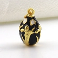 Detail van eivormige gouden hanger met zwart email en bloemreliëftextuur op metaal - Zwarte Plantentextuur Stijl (11)