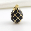 Detailed close-up of egg-shaped pendant with black enamel and golden grid pattern - Black Gold Grid Style