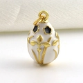 Detailopname van een witte emaille eivormige hanger met gouden Franse lelie patronen - Witte Fleur-de-lis Stijl (12)