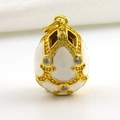 Close-up of gold-plated Faberge-style egg pendant with white enamel and sparkling crystals - White Grained Relief Diamond Style