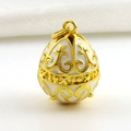 Macro view of white enamel 18k gold plated Fabergé style egg pendant with filigree details - Cream White Symmetrical Relief Style