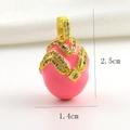Macro detail of pink enamel Easter egg pendant with gold wavy lines and cubic zirconia - Pink Wave Pattern Rhinestone Style